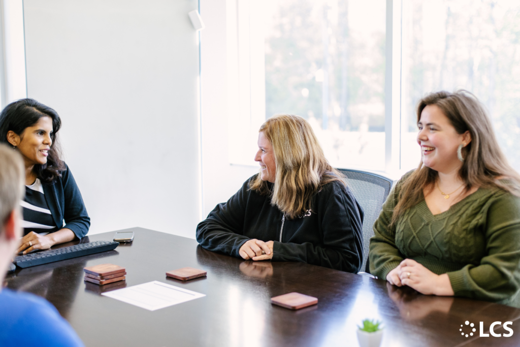 LCS employees networking and talking during a meeting at the office, 